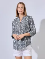 Blusa de gasa estampada, marca Ruby Rd. Cuello a la base, escote en V y abertura central con botones. Delantera con detalle plisado. Largo de manga regulable con presilla y botón.