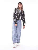 Blusa de mangas largas con estampado de hojas en tonos celeste y azul marino, con lazo en la cintura.