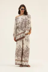 Pantalón palazzo de seda color crema con estampado floral en tonos marrones y cintura elastizada con cordón ajustable.