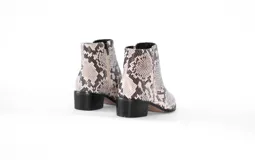 Botín con textura de reptil y taco de 4 cm, ideal para un look atrevido y lleno de personalidad.