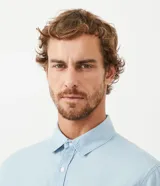 Camisa de manga corta confeccionada en tejido de algodón color azul denim, con cuello camisero, cierre frontal abotonado, bolsillo de parche en el pecho y corte comfort.