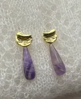 Par de aros colgantes con base dorada y dije de amatista en forma de lágrima.