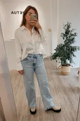 Jean wide leg celeste de tiro medio alto, con detalles de desgaste y mezcla de algodón y elastano.