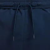 Pantalón largo de hombre Nike Club, color azul marino, con cintura elástica, cordón ajustable, bolsillos laterales y bolsillo cargo en la pierna izquierda.