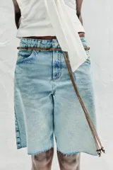 Bermuda de jean celeste de tiro medio con cinco bolsillos, efecto lavado y bajo sin costura.