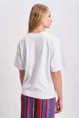 Remera blanca de corte boxy con estampa roja de la palabra "Bonjour".