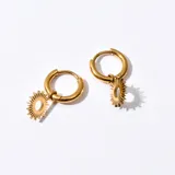 Aros enchapados en oro con diseño de sol colgante.