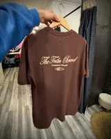 Remera marrón de corte oversize confeccionada en jersey 100% algodón, con estampa en color crema en la espalda con la frase "The Tribu Brand Creative Studio".