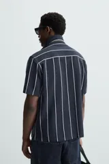 Camisa de hombre a rayas verticales color beige y blanco, de corte relaxed fit, manga corta y cuello bowling.