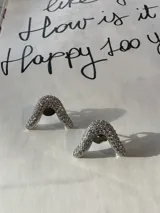 Aros plateados con forma de "V" invertida, con incrustaciones de circonitas.