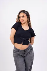 Remera corta de punto canalé color rosa, con escote en V, mangas cortas con volados y cierre frontal con botones.