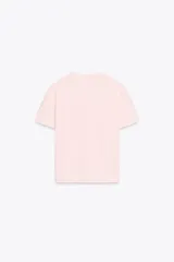 Camiseta blanca de algodón de manga corta y cuello redondo con detalle de flores en relieve en el frente.