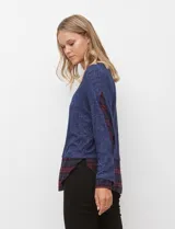 Buzo azul melange de tejido soft con ruedo y mangas combinadas en camisa a cuadros azul y bordeaux.