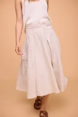 Pollera midi color beige de lino, con cintura ajustable con botón y bolsillo cargo en el lateral.