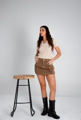 Remera beige de tejido calado con cuello polo y mangas cortas.