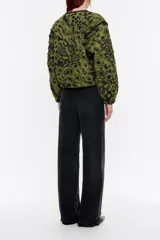 Cazadora corta acolchada de lino con estampado animal print en tonos verde oliva y negro. Tiene cuello redondo, cierre con botones a presión, mangas largas con volumen y puños fruncidos.