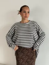 Sweater de punto a rayas horizontales blancas y negras, de corte holgado y mangas largas.
