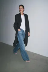 Pantalón de jean de tiro medio, pierna ancha y largo hasta el tobillo. Cintura con trabillas ajustable con cordones a contraste. Cinco bolsillos. Efecto lavado. Cierre frontal con cremallera y botón.