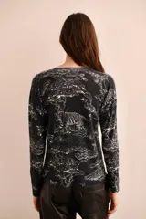 Sweater negro con estampado de tigres y árboles en blanco, cuello en V y mangas largas.
