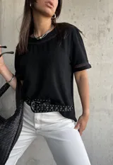 Remera negra de mangas cortas con detalle de encaje en cuello y mangas.