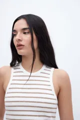 Musculosa corta a rayas horizontales blancas y negras con ribete negro en cuello y sisas.