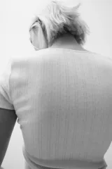Remera corta blanca de punto suave con textura acanalada. Modelo ajustado con costura fruncida en el centro del busto y escote corazón pronunciado con ribete de picot.