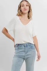Remera tejida color blanco, con escote en V y mangas cortas.