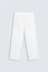 Pantalón blanco de lino, corte recto, con cintura elástica ajustable con cordón, bolsillos laterales y traseros.