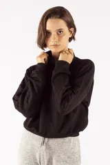 Buzo negro de corte relajado con cuello elevado tipo polera y mangas acanaladas.