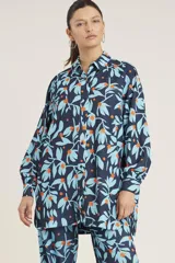 Pantalón con estampado colorido de flores sobre fondo azul, de corte suelto y cintura elástica.