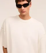 Remera oversized de algodón color crudo, con cuello redondo, manga corta, sin estampa y ribete acanalado.
