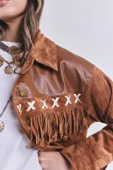 Campera marrón de gamuza con flecos y detalles en cuero sintético en la parte superior. Corte suelto.