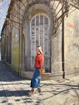Blusa color terracota de muselina con escote en V y lazos para ajustar. Tiene mangas largas abullonadas con volados en los puños.