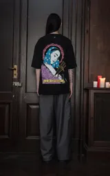 Remera negra de manga corta y cuello redondo, con calce oversize. Presenta una estampa sublimada inspirada en el tarot, con la imagen de una mujer de cabello azul con estrellas, tres espadas y rosas moradas, y la frase "3 DE ESPADAS" en una cinta.