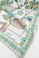 Pañuelo cuadrado de tela fina color blanco con estampado floral estilo paisley en tonos rosa, celeste, verde y azul.