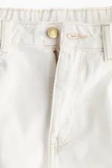 Short de jean blanco de tiro alto, con cinco bolsillos, corte holgado y bajo desflecado.