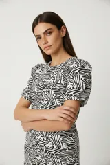 Remera de manga corta con estampado abstracto en blanco y negro, cuello redondo y corte holgado.