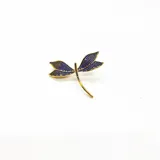 Broche en metal dorado con diseño de libélula, decorado con zirconias de colores, liviano y versátil.