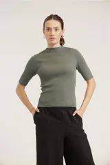 Blusa de punto color beige, de mangas cortas y cuello alto.