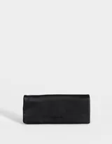 Billetera negra de cuerina con formato fichero, solapa con broche a presión y tag en relieve.
