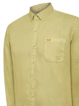 Camisa de lino color verde oliva, con cuello camisero, teñida en prenda. Tiene un bolsillo en el pecho con bordado al tono. De manga larga y calce regular.
