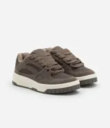 Championes de estilo urbano, color beige claro, con cordones gruesos trenzados y suela ancha de plataforma en tonos crema y gris. Presenta recortes en material sintético liso y gamuzado.