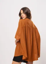 Camisa marrón con calados, escote en V, abotonada y manga 3/4.