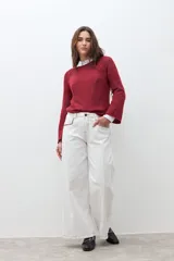 Sweater de tejido de punto color rojo oscuro jaspeado, con cuello redondo y mangas largas estilo raglán.