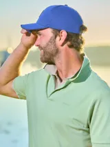 Gorra de gabardina color gris con visera curva y aplique de cuero con logo en el frente. Ajuste trasero con hebilla metálica.