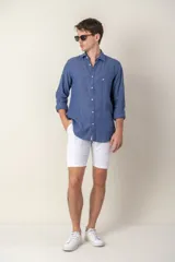 Camisa celeste de lino con cuello clásico y manga larga. Presenta un pequeño logo bordado en el pecho.