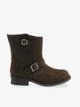 Bota corta de cuero marrón oscuro, estilo biker, con caña media y hebillas metálicas decorativas en el cuello y sobre el empeine. Posee un taco bajo y suela gruesa.