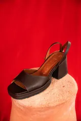 Sandalia de tacón cuadrado color negro, con diseño abierto y tiras para el tobillo.