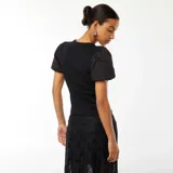 Camiseta negra entallada de tejido de punto acanalado, con cuello redondo y mangas cortas abullonadas de tela lisa.