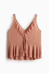 Musculosa color salmón con escote en V pronunciado, breteles anchos y detalle de volados en el escote y en el bajo de doble capa.